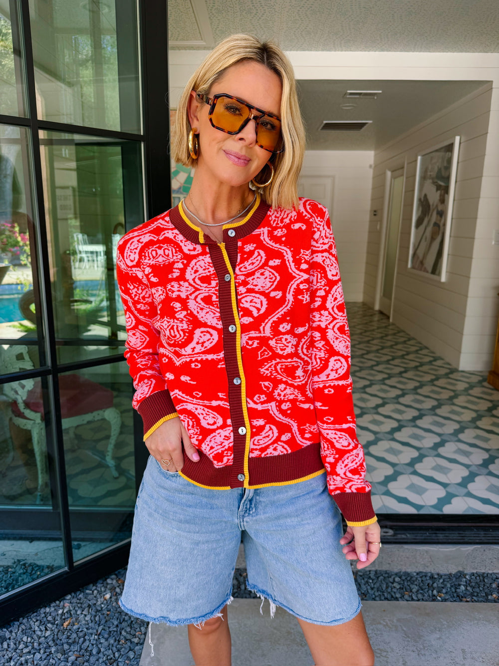 Woman wearing red bandana cardigan. Viral bandana cardigan. Wear to rodeos or just for western look.