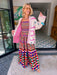 A woman wearing a cream-colored embroidered, beaded kimono-style jacket with pink striped trim and sunshine motif