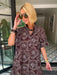 A woman wearing a brown and blue bandana patterned maxi shirt dress with short sleeves. Wear to a rodeo or western event. Gameday, Rodeo, Longhorn Football, Western