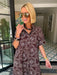 A woman wearing a brown and blue bandana patterned maxi shirt dress with short sleeves. Wear to a rodeo or western event. Gameday, Rodeo, Longhorn Football, Western