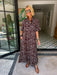 A woman wearing a brown and blue bandana patterned maxi shirt dress with short sleeves. Wear to a rodeo or western event. Gameday, Rodeo, Longhorn Football, Western


