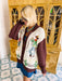 A woman wearing a western, rodeo themed cardigan sweater with brown sleeves. This cardi features cowboys and cowgirls lassoing, doing rope tricks. Perfect for rodeo, FW stockyards, stock show or any western event. Style with denim or over any dress.