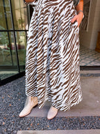 A woman wearing a blue and brown zebra print midi skirt set. This short sleeve top and midi skirt can be worn together for fun coordinated look or worn separately. Wear to a concert, rodeo or date night. Pair with boots or sneakers.