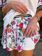 Woman wearing sporty, edgy floral skort. Has built in shorts with pockets! Perfect for moms running errands or carpooling. Pair with matching top or any tee.
