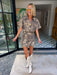A woman wears an edgy tiger print romper. Gameday look for LSU Tigers. Concert outfit. Trendy tiger print.