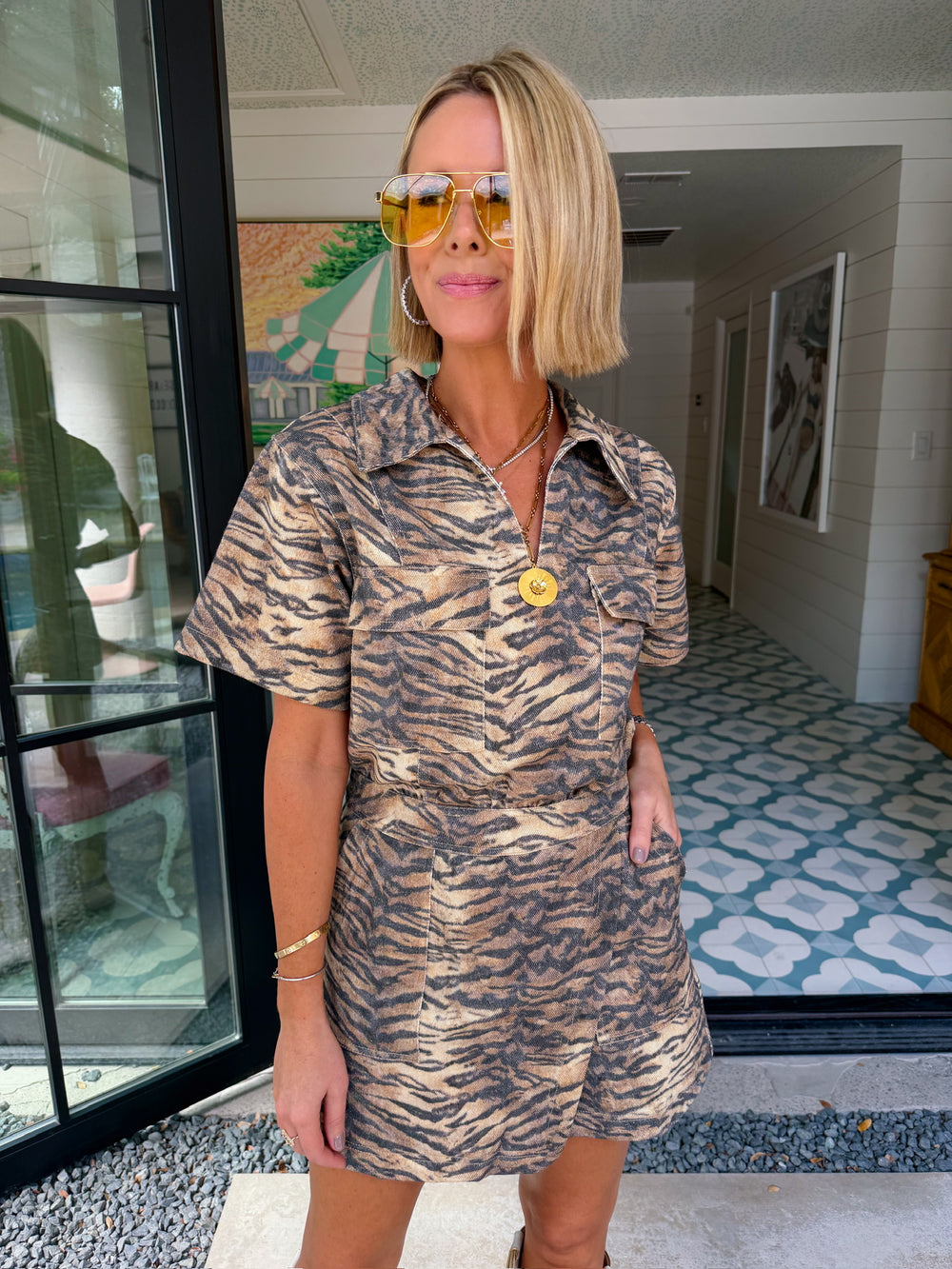 A woman wears an edgy tiger print romper. Gameday look for LSU Tigers. Concert outfit. Trendy tiger print.