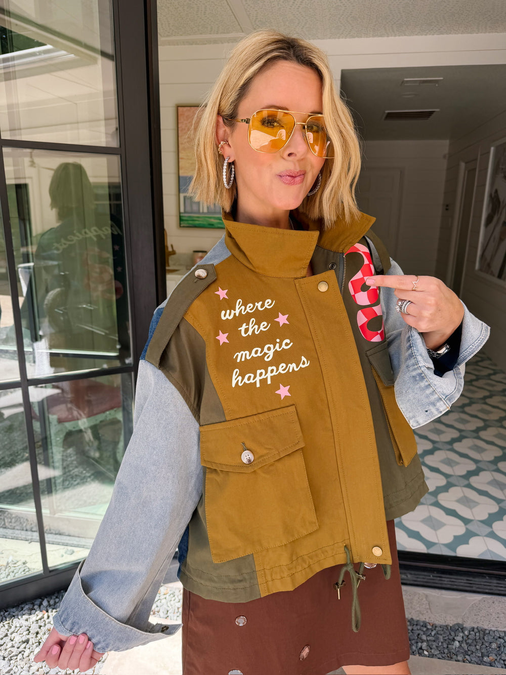A woman models a color-block utility jacket with denim and green colorblocking. Wear this jacket to round top, a rodeo, or running around town. The best  lightweight, casual fall layer. A must have for busy chic moms on the go.