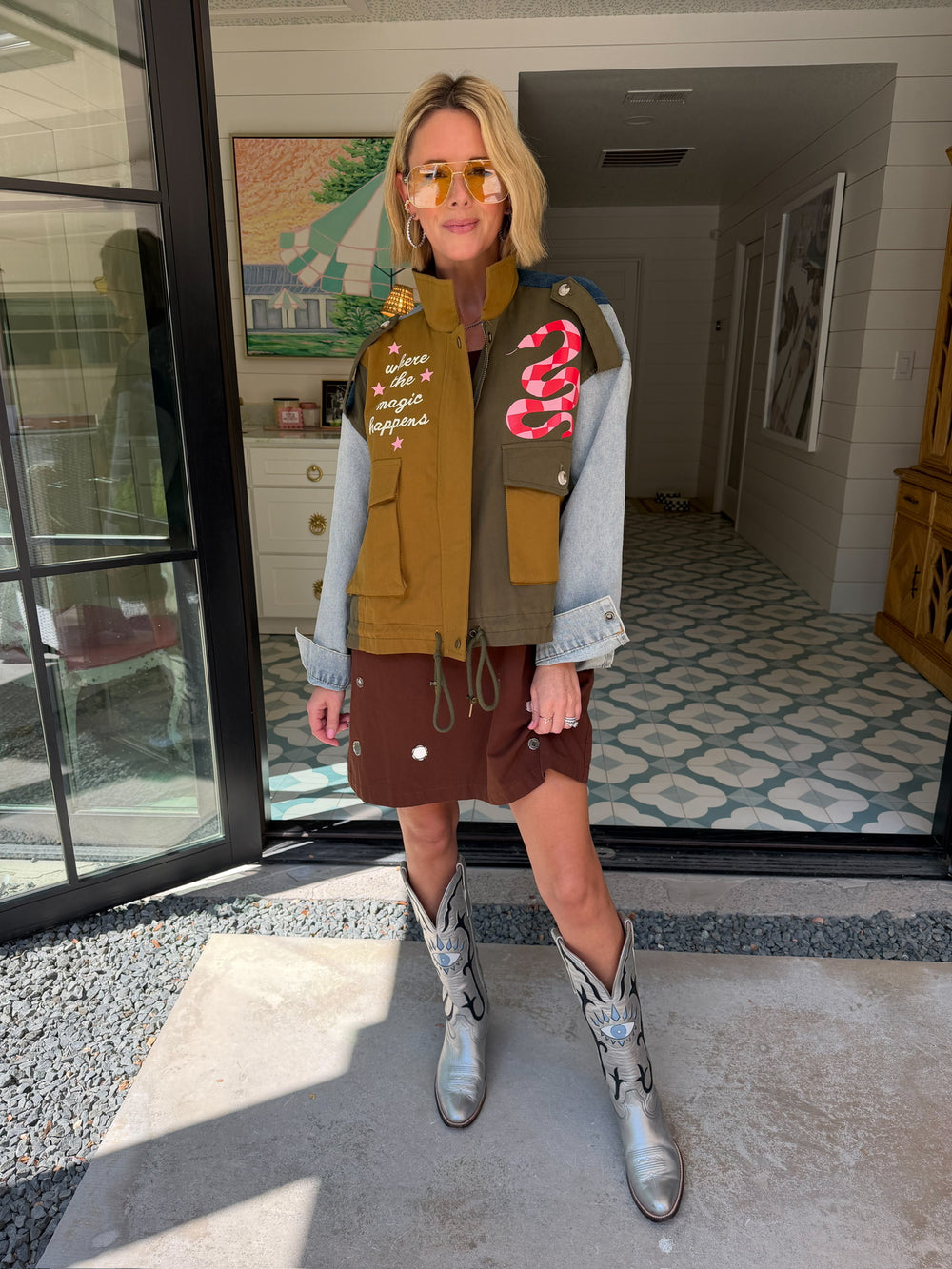 A woman models a color-block utility jacket with denim and green colorblocking. Wear this jacket to round top, a rodeo, or running around town. The best  lightweight, casual fall layer. A must have for busy chic moms on the go.