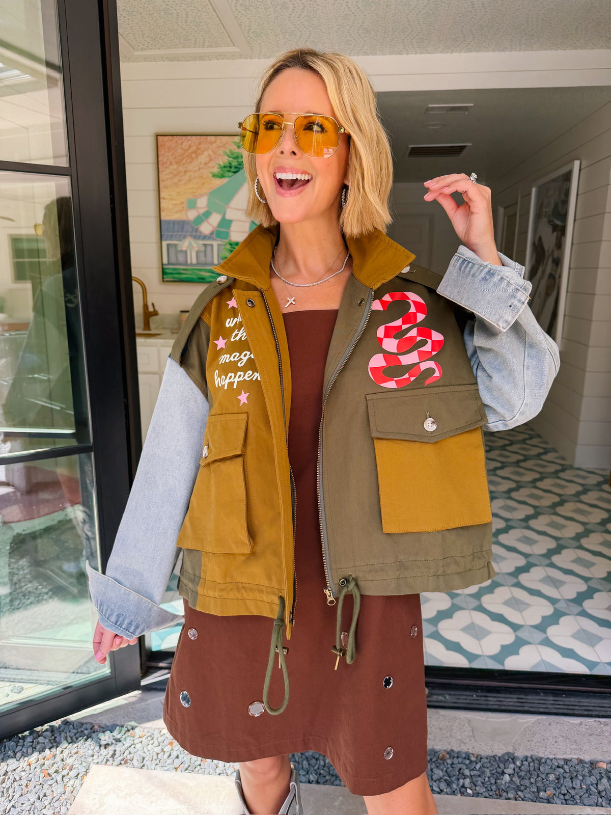A woman models a color-block utility jacket with denim and green colorblocking. Wear this jacket to round top, a rodeo, or running around town. The best  lightweight, casual fall layer. A must have for busy chic moms on the go.