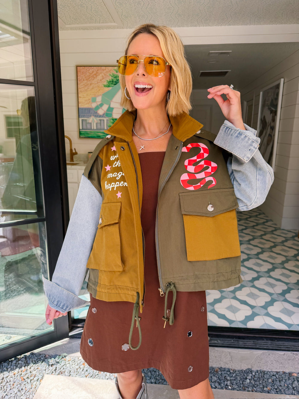 A woman models a color-block utility jacket with denim and green colorblocking. Wear this jacket to round top, a rodeo, or running around town. The best  lightweight, casual fall layer. A must have for busy chic moms on the go.