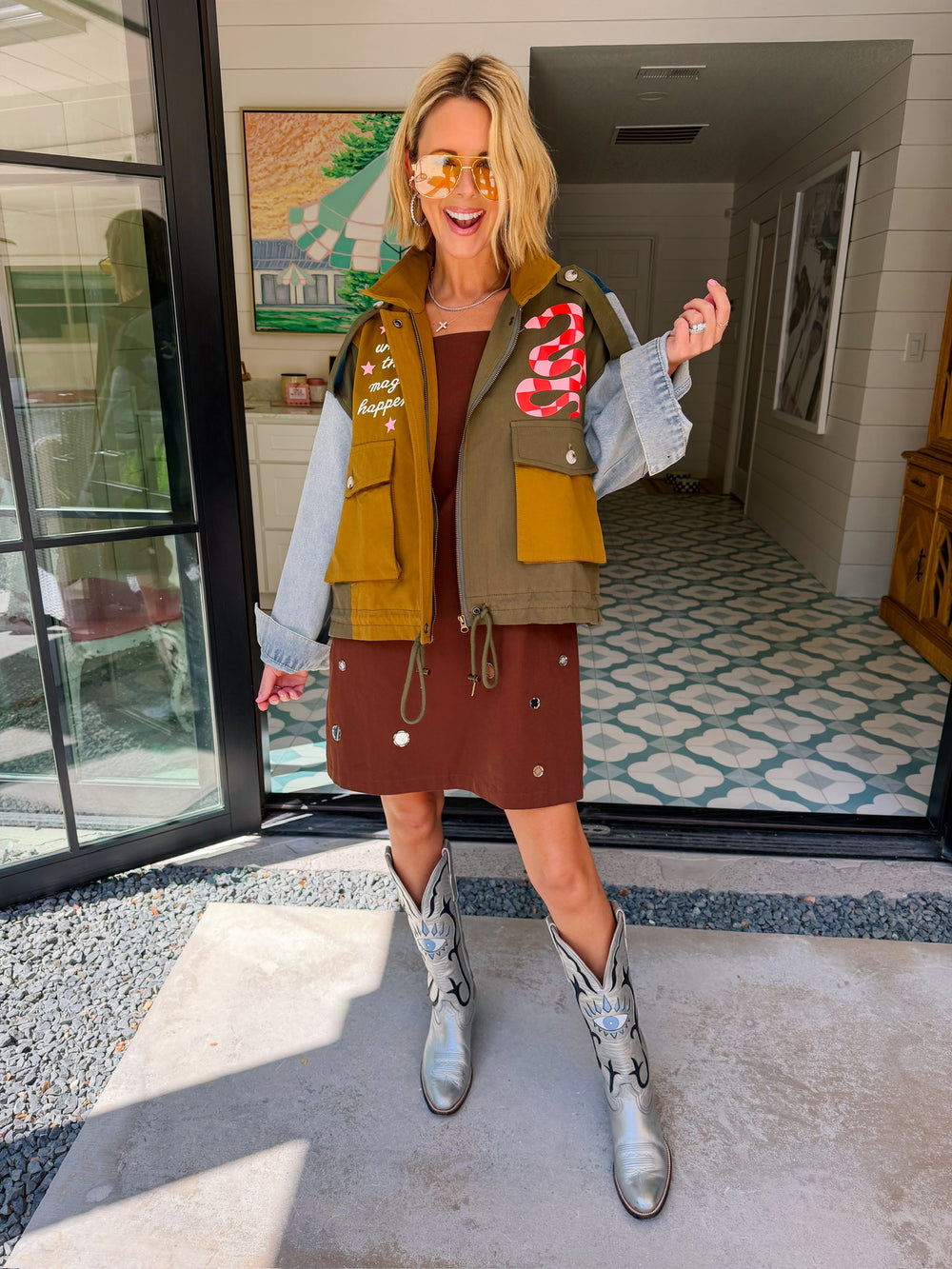 A woman models a color-block utility jacket with denim and green colorblocking. Wear this jacket to round top, a rodeo, or running around town. The best  lightweight, casual fall layer. A must have for busy chic moms on the go.