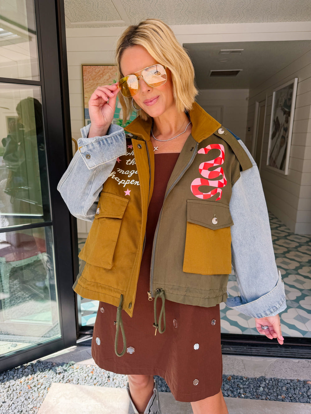 A woman models a color-block utility jacket with denim and green colorblocking. Wear this jacket to round top, a rodeo, or running around town. The best  lightweight, casual fall layer. A must have for busy chic moms on the go.